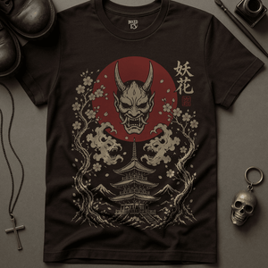 Dark t-shirt with a graphic design featuring a demon face, cherry blossoms, and a temple on a gray surface.